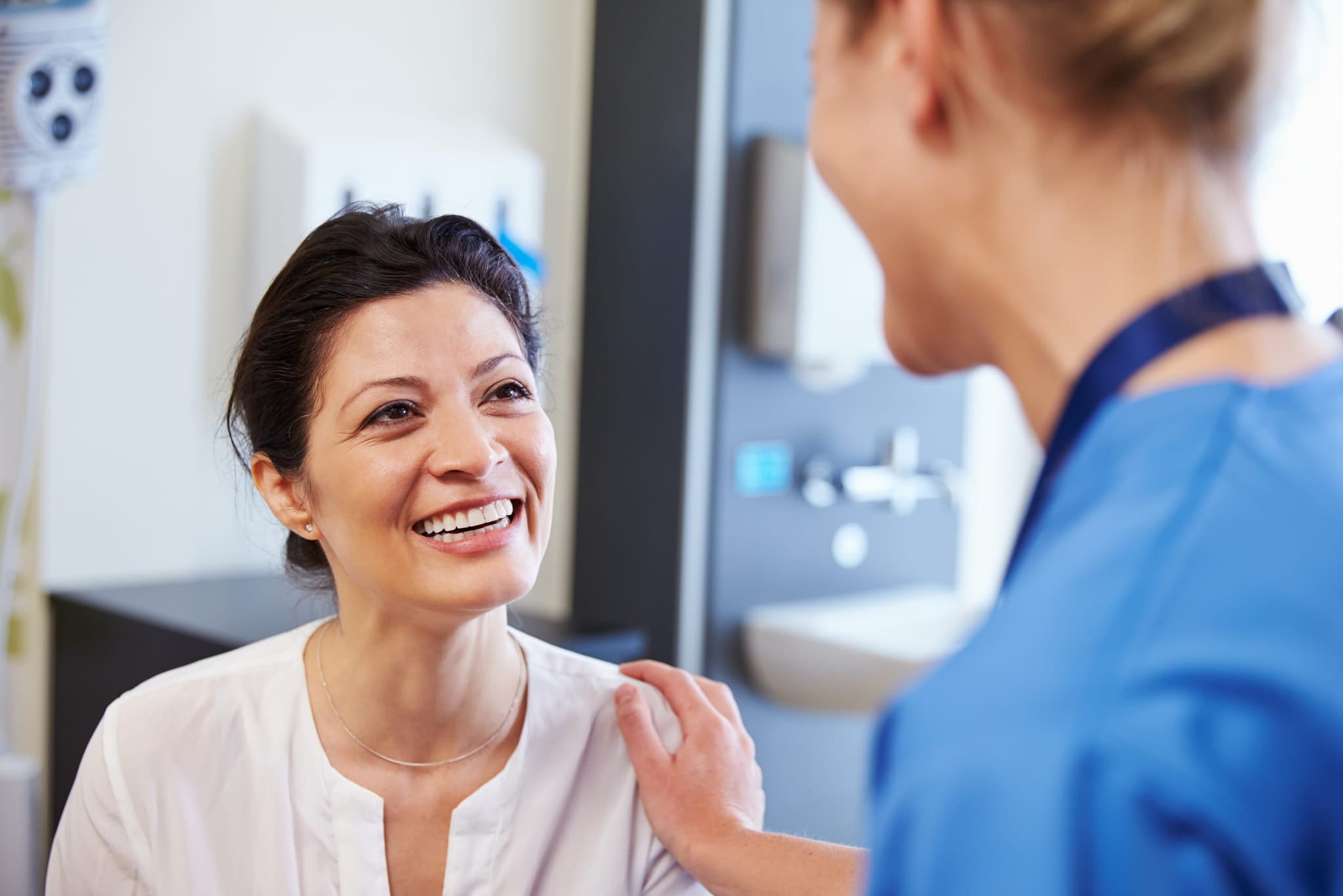 Una enfermera de California Renal Care sonriendo con calidez durante una visita con una paciente
