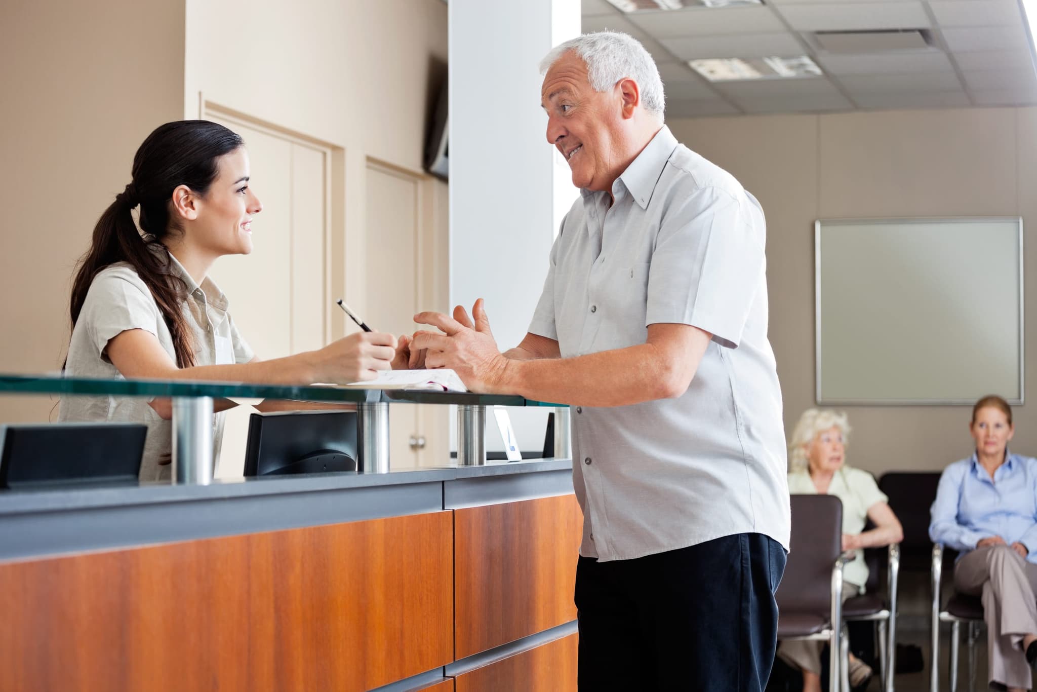 Una acogedora área de recepción en una clínica de California Renal Care, con una recepcionista amable lista para registrar a los pacientes